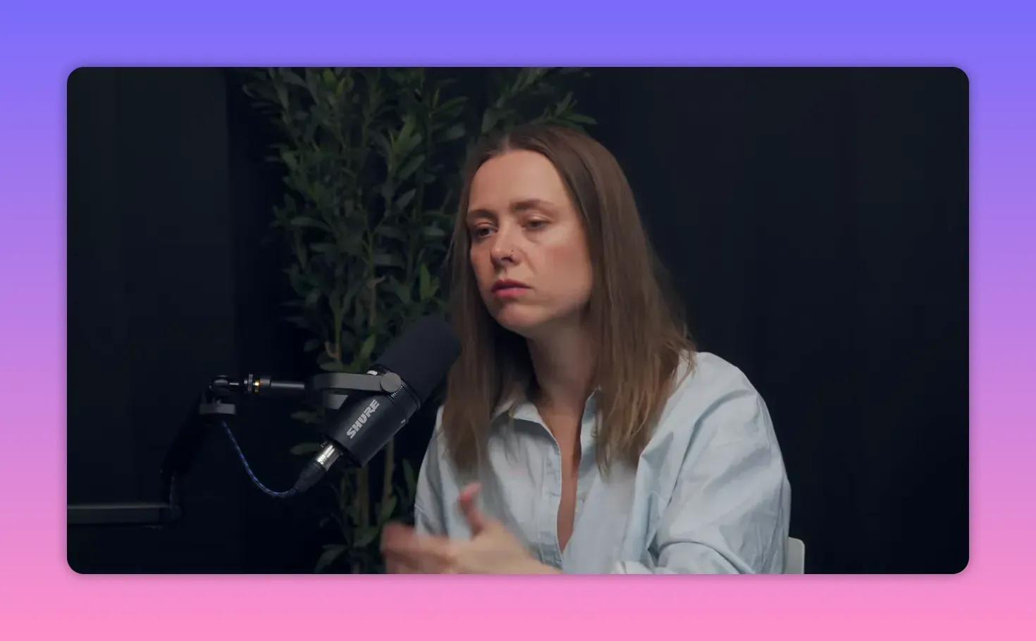 Средний план Елены с микрофоном, жестикулирующая во время интервью.