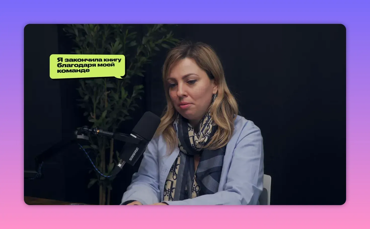 Женщина в студии подкаста с речевым блоком на экране: «Я закончила книгу благодаря моей команде», средний план.