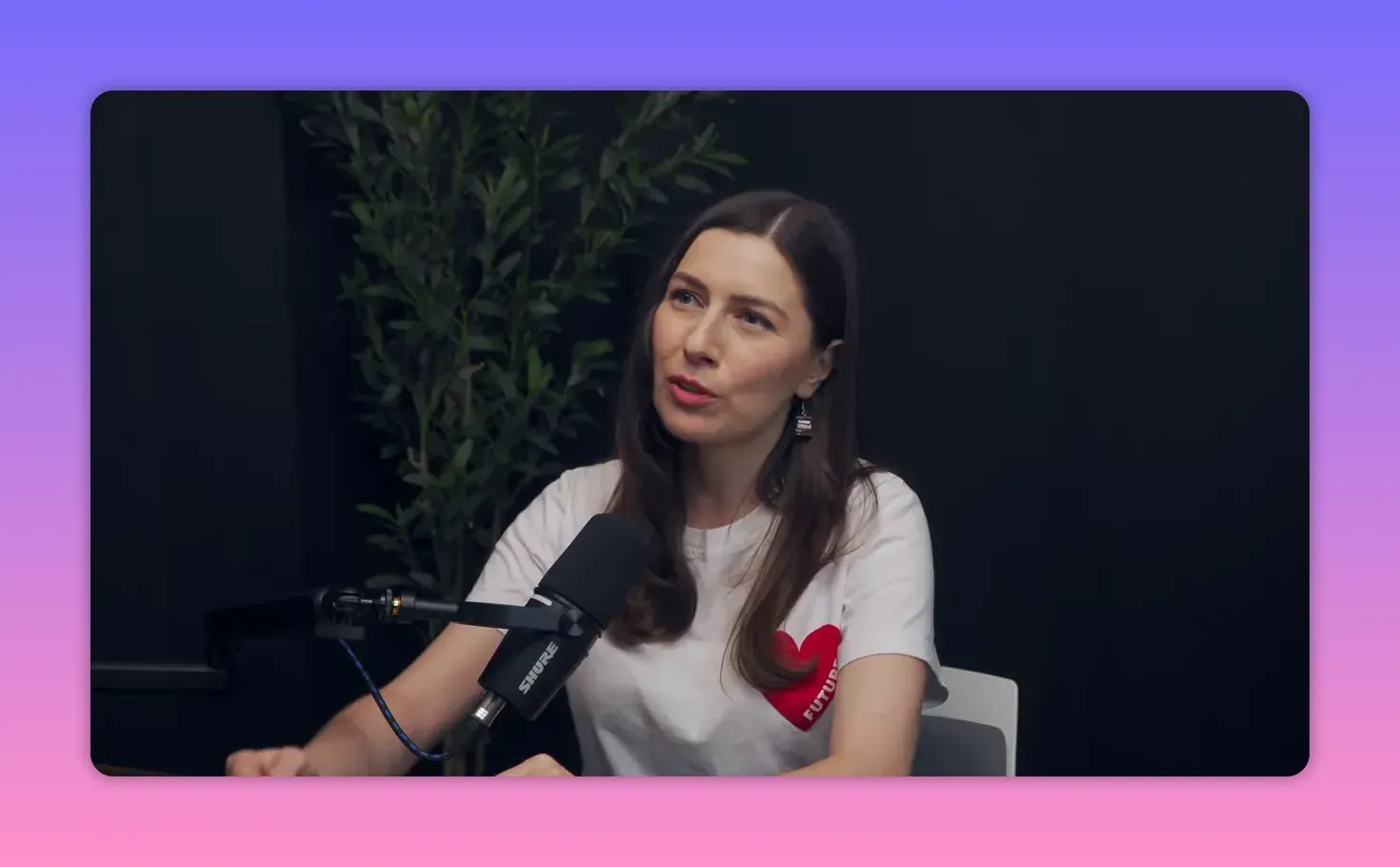 Майя Иванова в студии у микрофона в среднем плане, в белой футболке с красным сердцем и надписью «Future», спокойное выражение лица.
