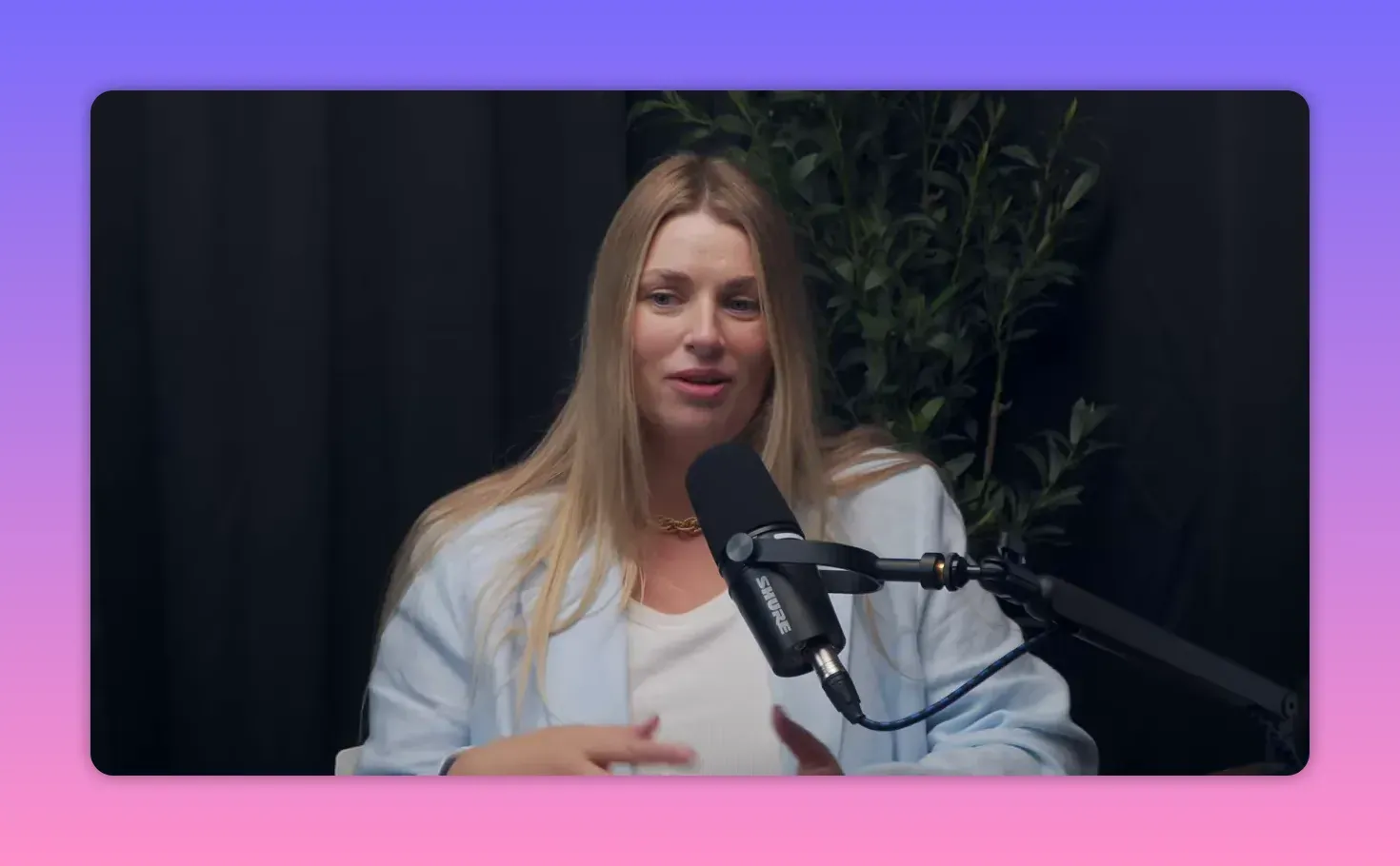 Алёна Гладкова жестами рассказывает историю в подкасте, виден микрофон